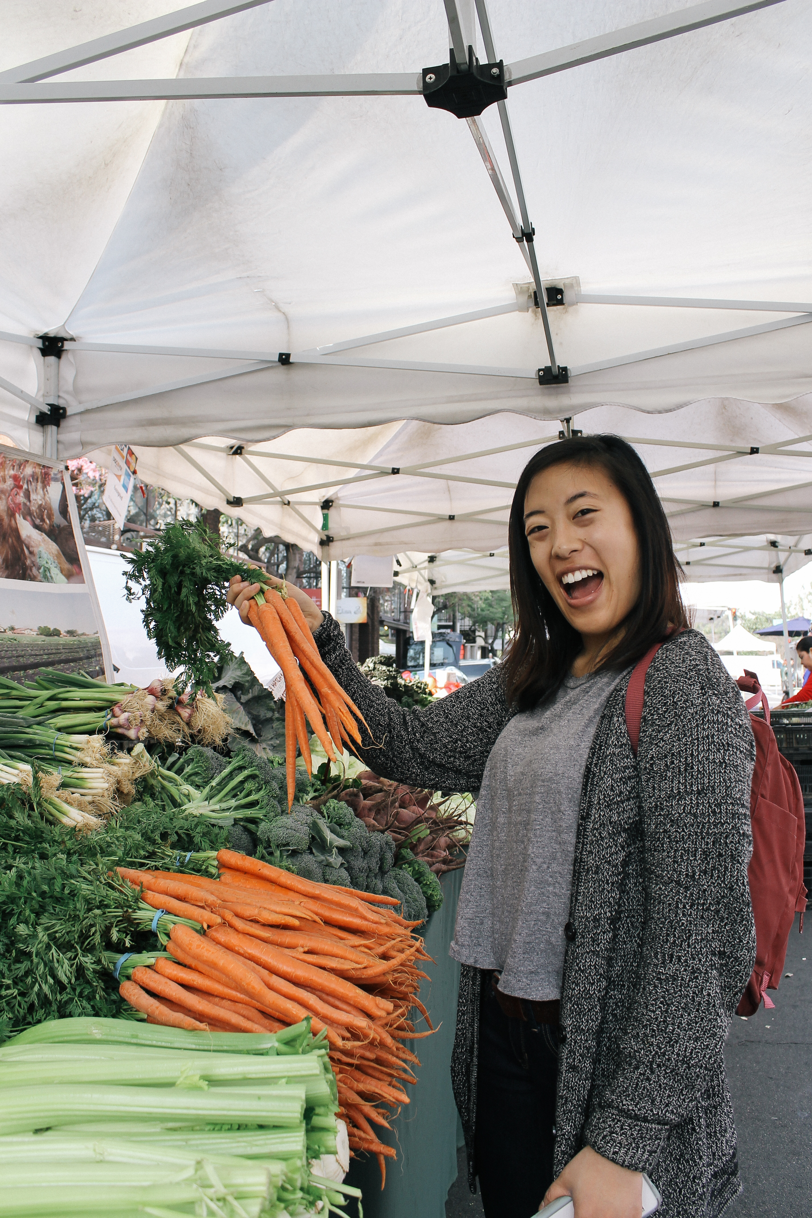 Vivian picking up fresh carrots from the farmers market