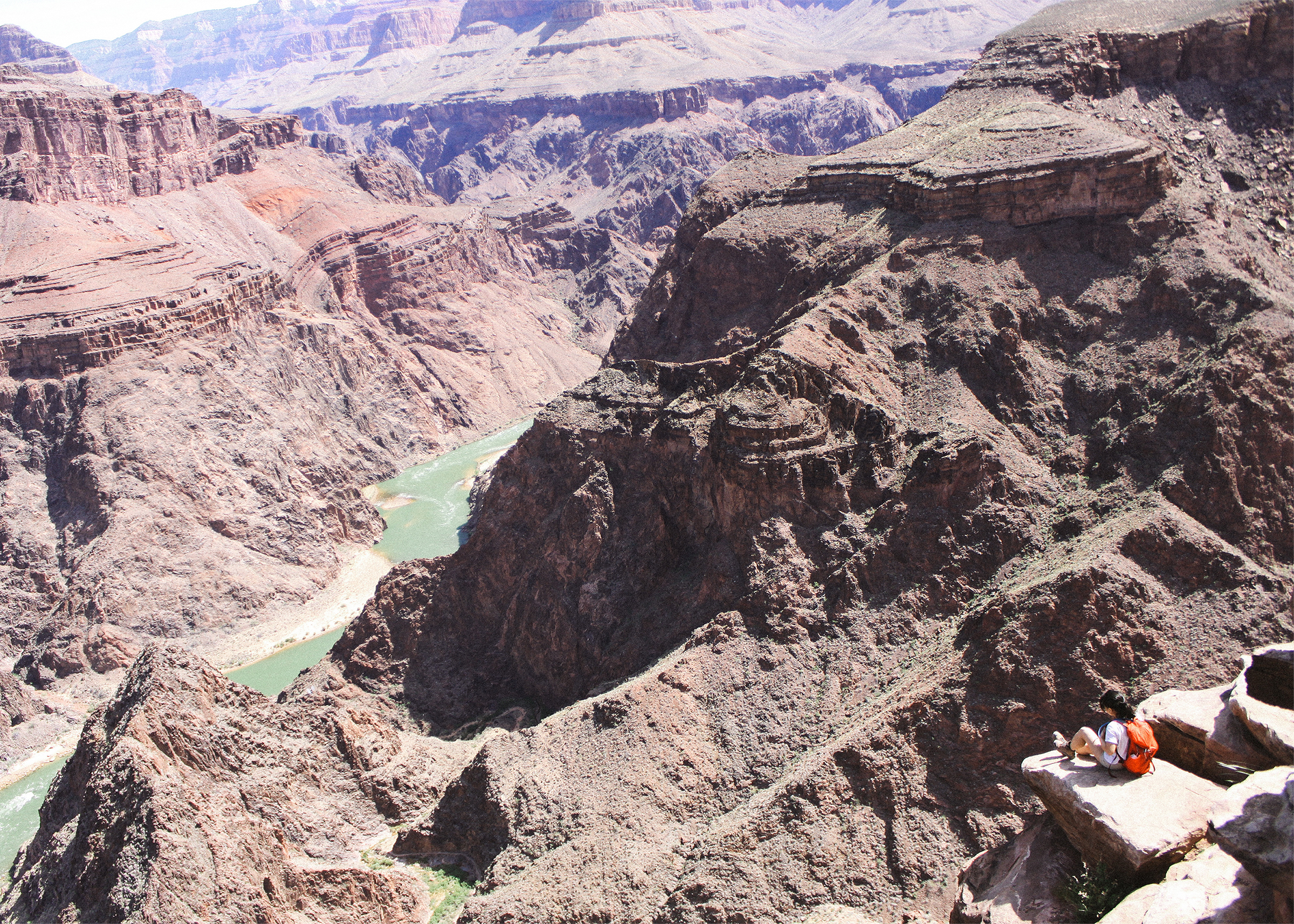 Jennifer sitting at Plateau Point with the Colorado River beneath her