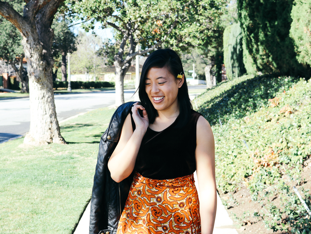 Vivian in a velvet top, knee length wrap skirt, and a leather jacket.