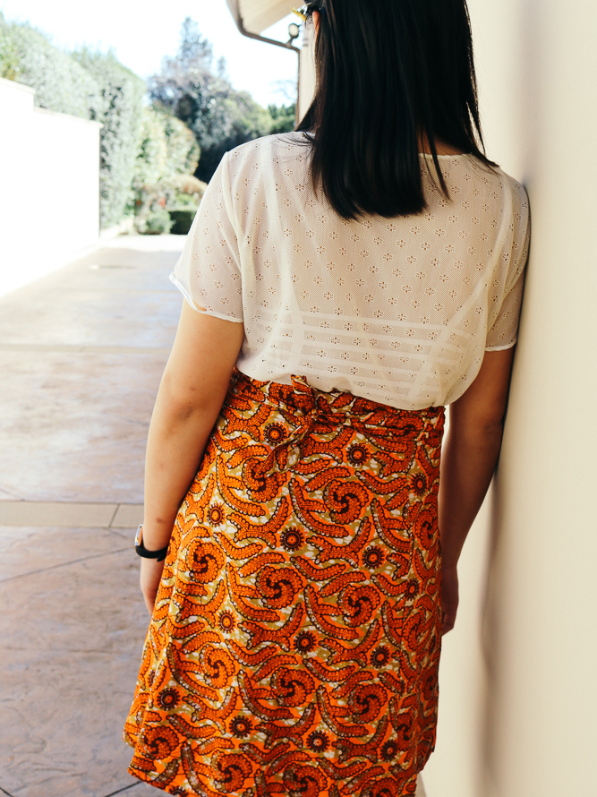 Vivian in a laced top and knee length wrap skirt.