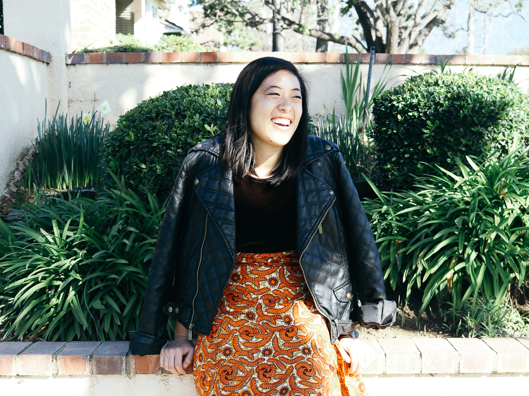 Vivian in a velvet top, knee length wrap skirt, and leather jacket.